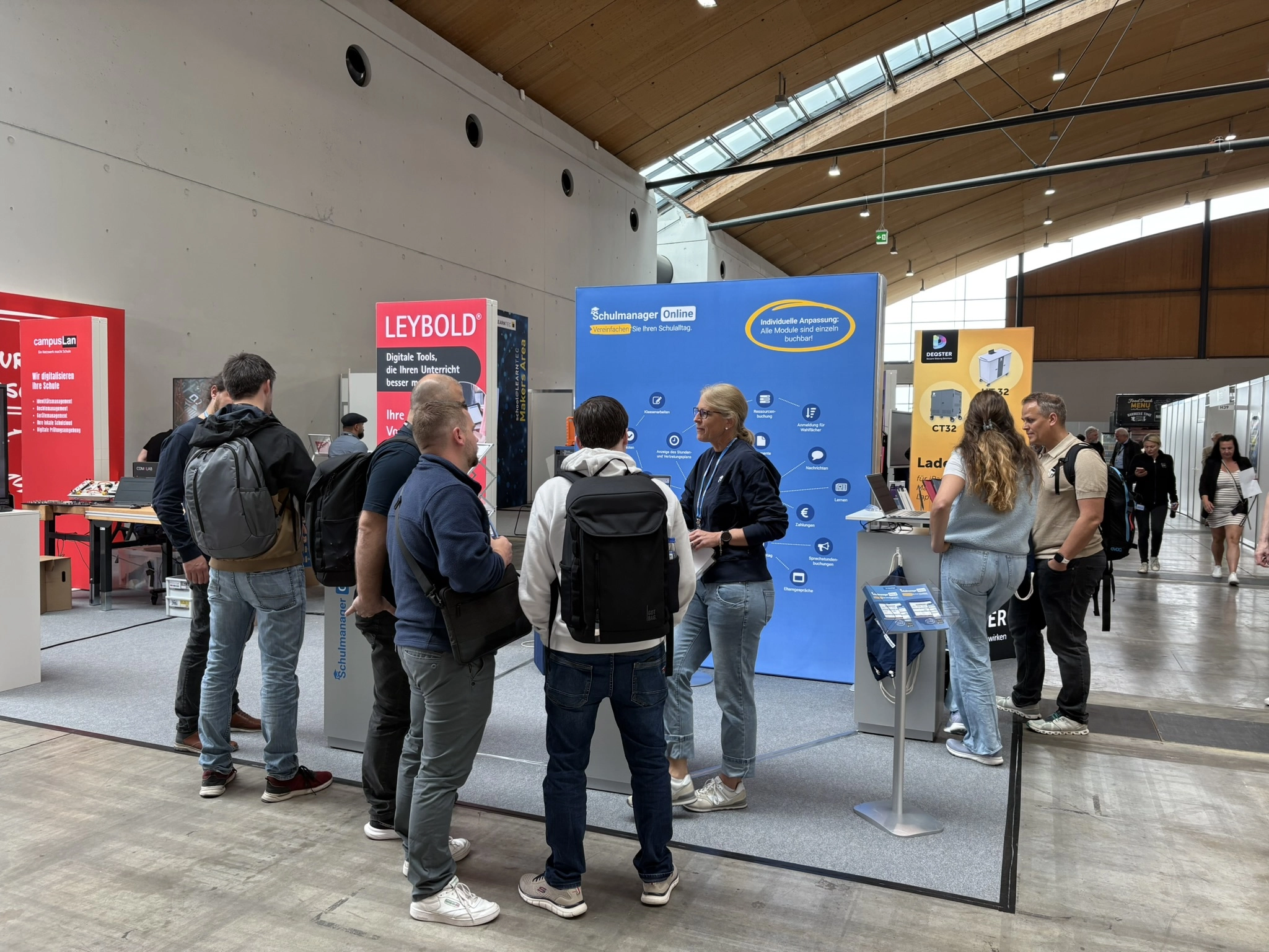 Das Team von Schulmanager Online am Messestand in Gespräche mit Besuchern vertieft